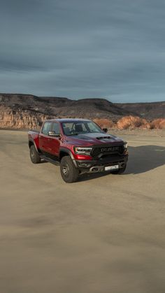 a red truck is parked in the desert