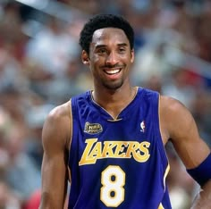 a basketball player is smiling and wearing a purple uniform