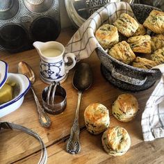 there are some muffins on the table next to a cup and spoon with liquid in it