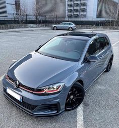 a grey car parked in a parking lot next to other cars