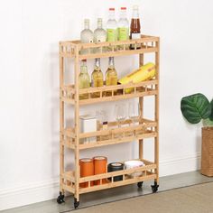 a wooden shelf with bottles and glasses on it next to a potted green plant