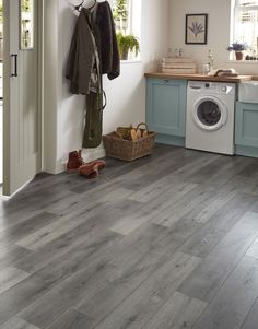 a laundry room with grey wood floors and blue cabinets