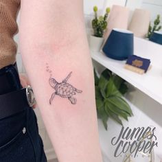 a small turtle tattoo on the right forearm and arm, with an inking effect