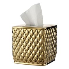 a gold tissue dispenser with a white napkin in it's holder