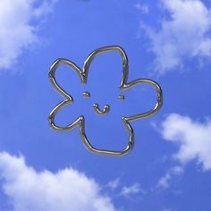 a metal object in the shape of a flower on a blue sky with white clouds