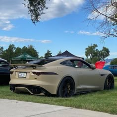 a tan sports car parked in the grass