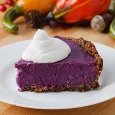 a piece of pie with whipped cream on top sits on a plate next to other fruit