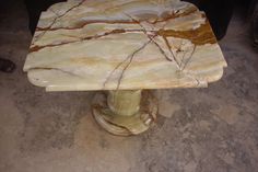 a marble table sitting on top of a cement floor