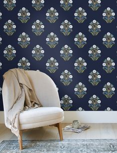 a chair sitting in front of a blue wallpaper with skulls and flowers on it