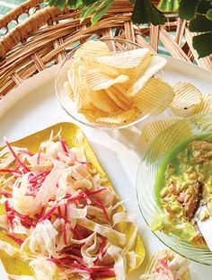 two plates with chips and coleslaw on them next to a bowl of salsa