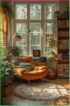 a living room filled with lots of plants and furniture next to a large window on top of a hard wood floor