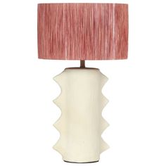 a white ceramic table lamp with a pink shade