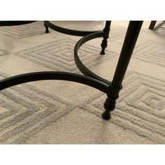 a close up of a metal table with a white rug on the floor behind it