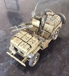 a toy army vehicle is sitting on the ground with wheels and tires attached to it