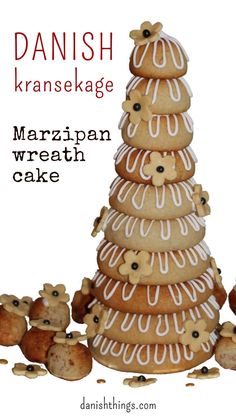 a large stack of cookies with white icing and toppings on top, in front of the words danish kransekage marzipan wreath cake