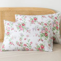 two pillows on a bed with pink flowers