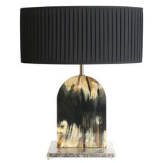 a table lamp with a black shade on the base and a marble base underneath it