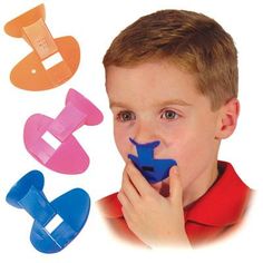 a young boy holding three pieces of blue and pink plastic in front of his face