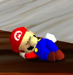 a nintendo wii game character laying on the ground with his head down and eyes closed