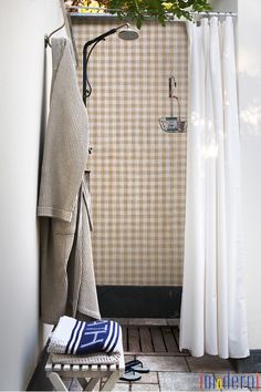 a bathroom with a shower, towel rack and planter on the wall next to it