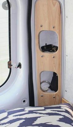 the interior of a camper with a bed and storage compartment on it's side