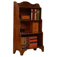 an old wooden bookcase with many books on it's shelves and two drawers