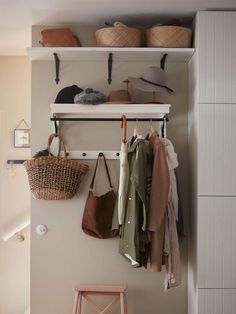 a coat rack with hats, coats and purses hanging from it's hooks