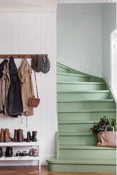 there is a coat rack on the wall next to shoes and purses hanging from hooks