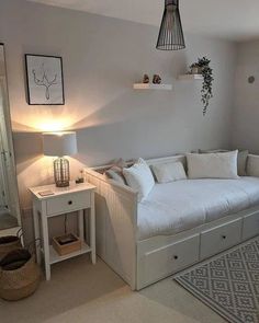 a living room with a couch, table and lamp on the wall next to it