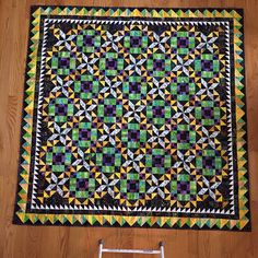 a quilt is laying on the floor next to a stepladder with a ladder