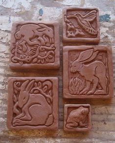 four clay blocks with animal designs on them