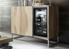 a wooden cabinet with an open door and wine bottles on top in a living room