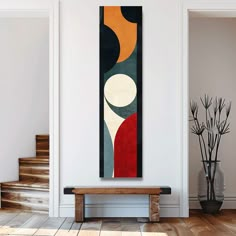 a painting hanging on the wall next to a wooden bench in a room with white walls