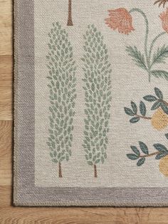 an area rug with trees and flowers on the floor in front of a wooden floor