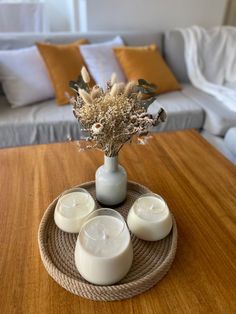 three candles are sitting on a table with flowers in a vase next to the candle holders