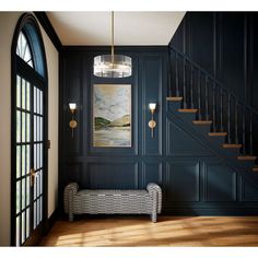 a room with dark blue walls and wood flooring, an entryway to the second floor