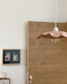 a baby's room with a wooden door and light fixture hanging from the ceiling