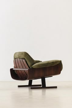 an old fashioned lounge chair with green velvet upholstered on the back and footrests