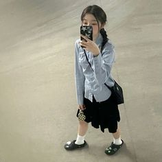 a woman taking a selfie with her cell phone in front of an empty parking lot