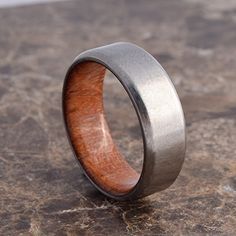 a wooden and metal ring sitting on top of a stone slab with a wood in the center