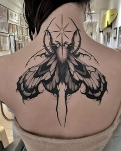 a woman with a butterfly tattoo on her back