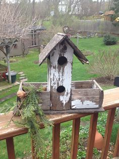 a bird house sitting on top of a wooden fence