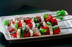 a white plate topped with meat and veggies on skewered toothpicks