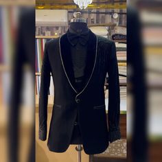 Make an edgy statement with our BLACK EMBROIDERED suit designed thoughtfully for the modern  man. A fusion staple fit for every occasion, adds the right amount of cultural twist to the western silhouette. Color: Black  Garment Type: Indo Western Neck: tuxedo Fabric: Micro Velvet Embroidery: Zari work with sequin embroidery The Product Price is inclusive of: 1 Indo-Western and 1 Trouser Style Bottom and 1 shirt Product color may slightly vary due to photographic lighting sources or your screen settings. ~We provide fully stitched outfits as per your measurements ~Outfits can be customised in any colours For customisation please contact  ~We provide worldwide shipping ~You choose we design. ~High quality dresses no replicas only hand embroidery ~Image is only for reference purpose ~Disclaime Handwork Tuxedo For Men, Luxury Designer Embroidered Tuxedo, Tuxedo Embroidery For Men, Designer Embroidered Tailored Tuxedo, Luxury Black Embroidered Tuxedo, Indian Jackets, Empire Outfit, High Quality Dress, Trouser Style