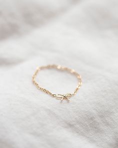 Add the perfect touch of sophistication to your outfit with this delicate bow chain ring. Made with high-quality 14k gold, it's durable enough for everyday wear while remaining a subtle statement piece.• 14k Yellow Gold• Bow measures approx. 6mm Aesthetic Gold Bracelets, Dainty 14k Gold Chain Ring For Promise, Dainty Yellow Gold Chain Ring For Promise, Gold Dainty Promise Chain Ring, Dainty Gold Promise Chain Ring, Delicate Chain Yellow Gold Ring For Gift, Dainty Chain Ring With Adjustable Chain, Delicate 14k Gold Adjustable Chain Ring, Delicate 14k Gold Chain Ring With Adjustable Chain