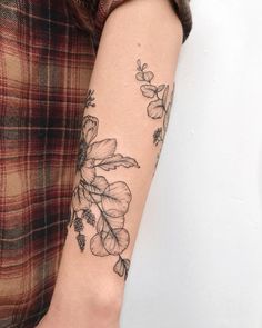 a woman's arm with a flower tattoo on the left side of her arm