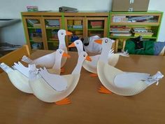 three paper plates shaped like ducks sitting on a table