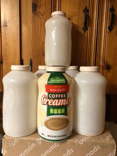 coffee creamer and milk bottles sitting on top of a cardboard box