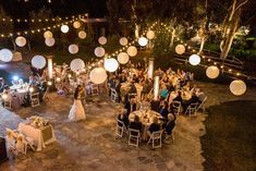 an overhead view of a wedding reception at night with paper lanterns strung from the ceiling