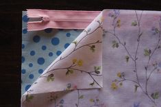 two pieces of fabric with flowers and polka dots on them, one half rolled up